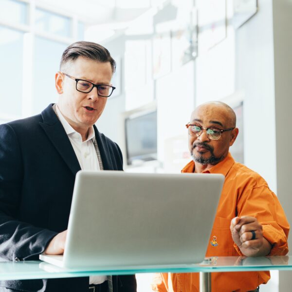 Consultant Using Laptop Beside Another Man